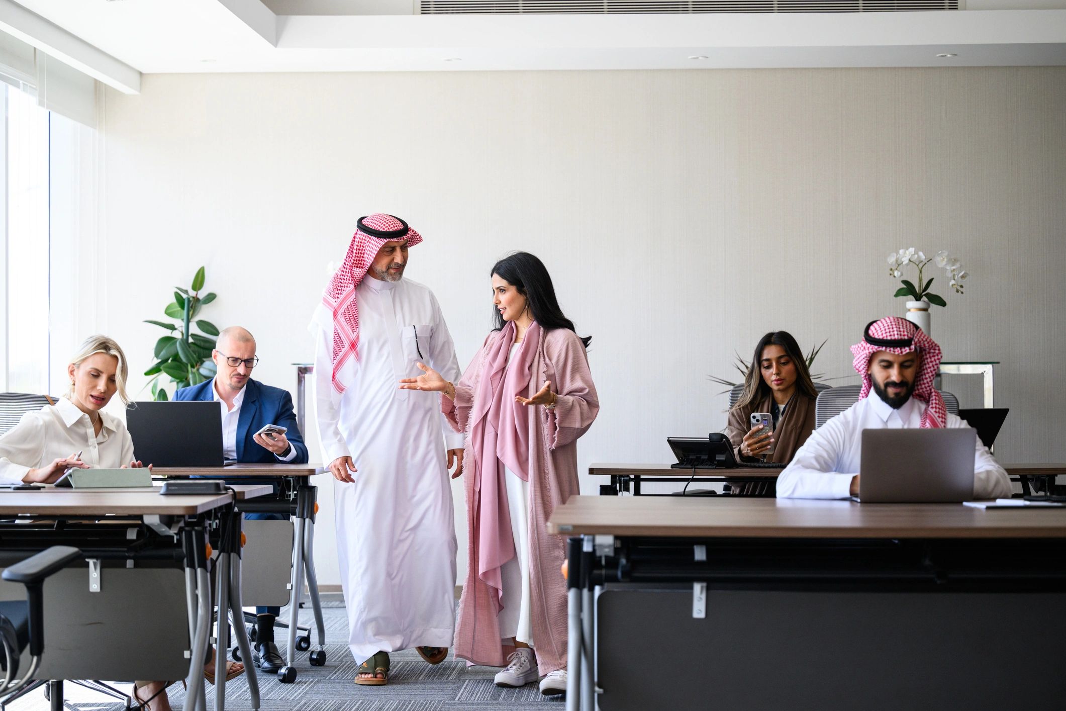 Wide shot of multicultural business team collaborating in modern global office in Middle East